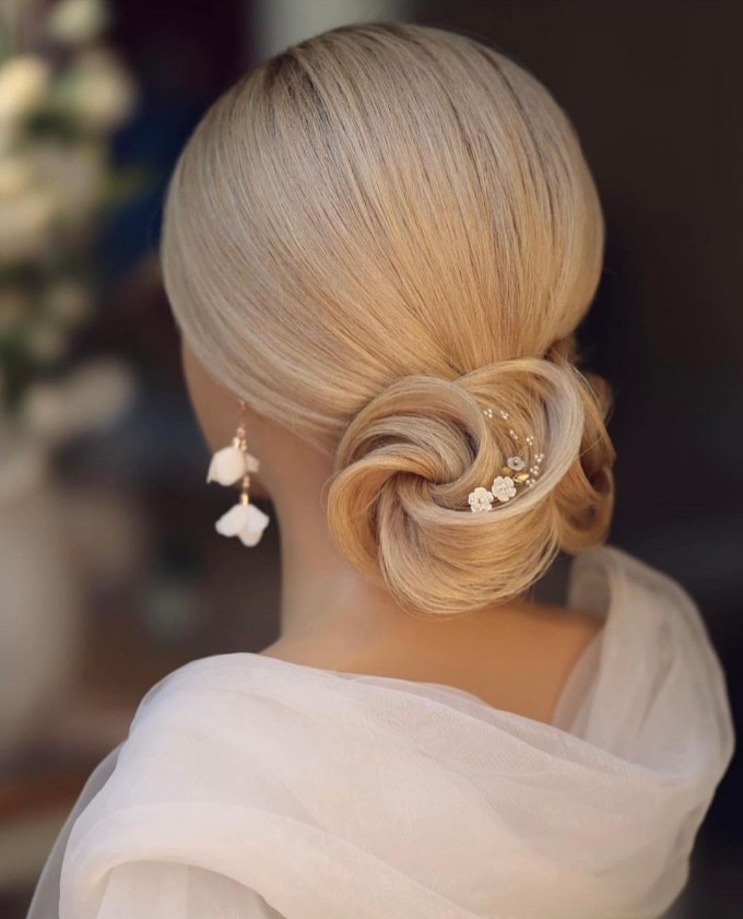 Smooth and Sleek Low Bun with Side-Swept Dama Hairstyles for Quinceaneras